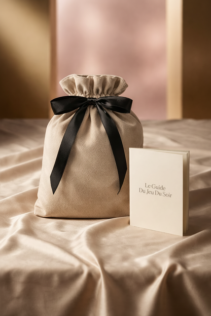 pochette de rangement le jeu du soir avec son guide de jeu romantique pas-à-pas  pour couple posé sur des draps satinés 